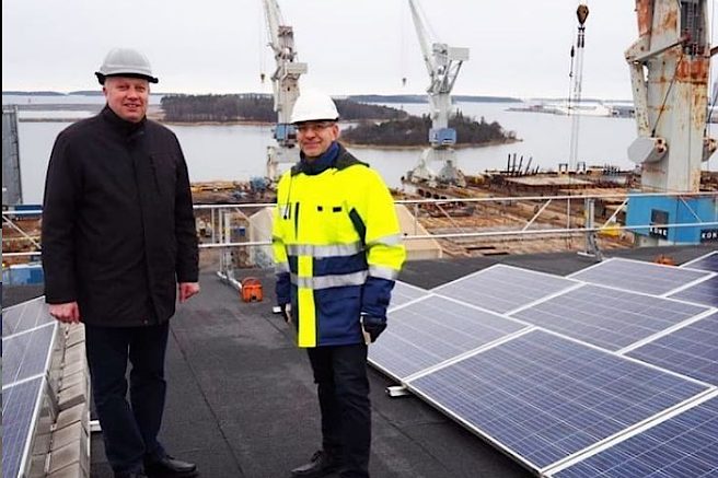 Rauman Energian kehitysjohtaja Juha Viherjälaakso ja Rauman Meriteollisuuskiinteistöt Oy:n toimitusjohtaja Timo Luukkonen seisovat katolla aurinkopaneelien vieressä.